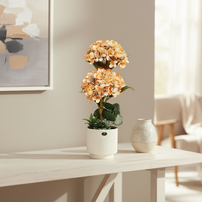 Potted plant with orange flowers on a table in a room with a painting and vase.