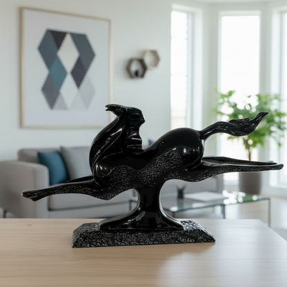 Black abstract sculpture on a wooden surface with a modern interior background