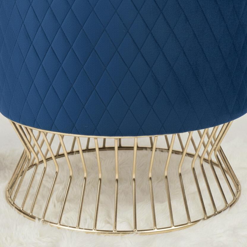 Blue ottoman with a gold wire base on a light background