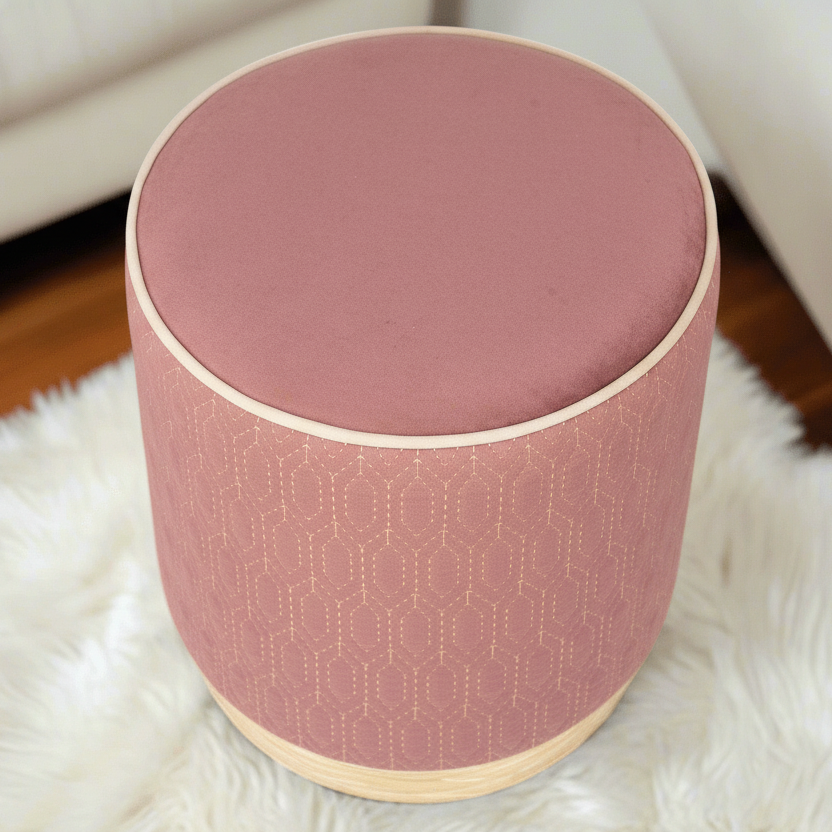 Round pink ottoman with geometric pattern on a white rug