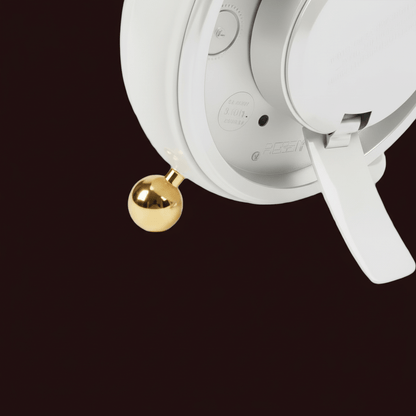 Close-up of a white electronic device with a gold ball on a black background