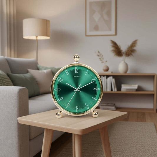 Green clock with gold rim and base on a white background