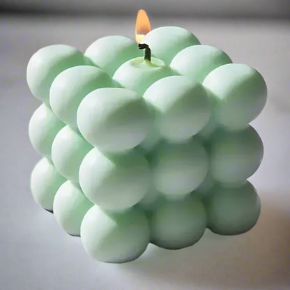 Cube-shaped soy wax candle with green bubbles