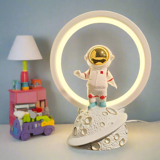 Decorative lamp with an astronaut design on a wooden surface.